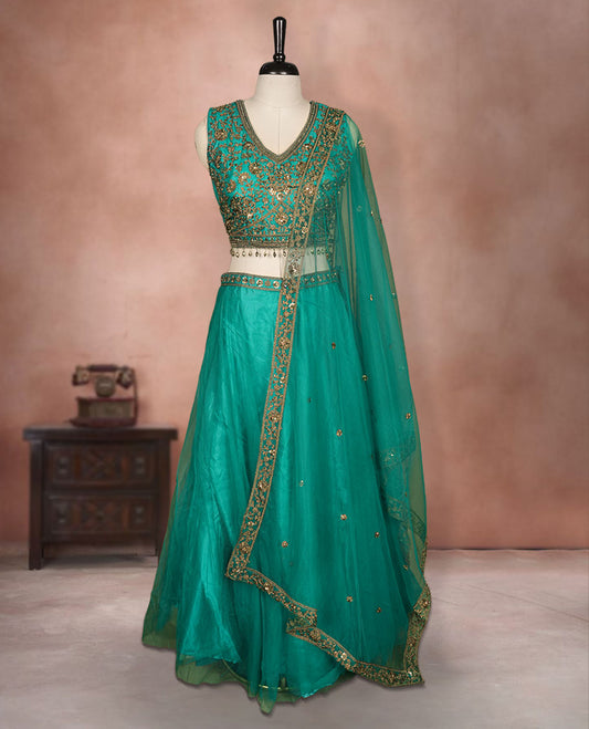 Green colour lehenga set with stitched sleeveless Antique thread embroidered & beats worked  blouse featuring sheer neckline, matching stitched flared lehenga, and plain sheer dupatta.