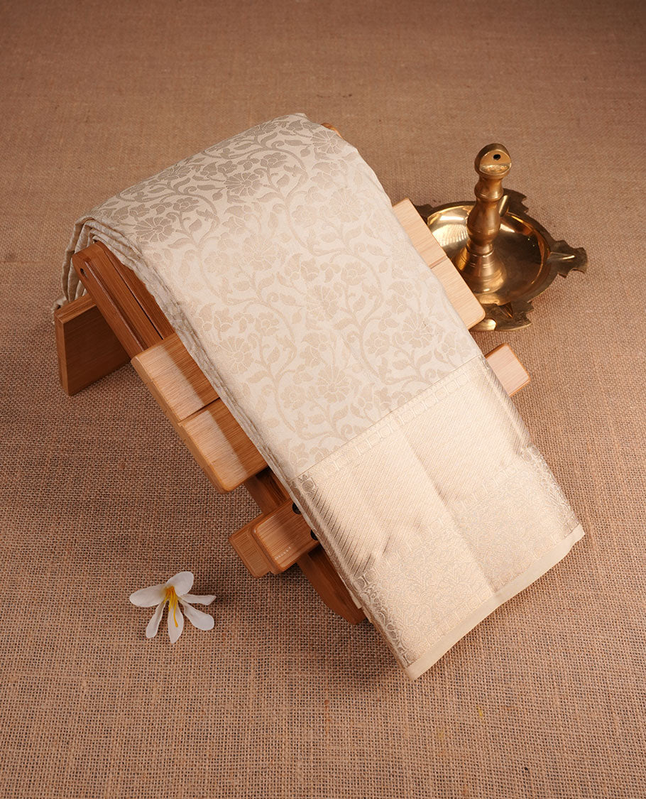 Cream colour Kancheepuram silk saree featuring antique silver floral jacquard on the body with a zari border, paired with a matching blouse piece.