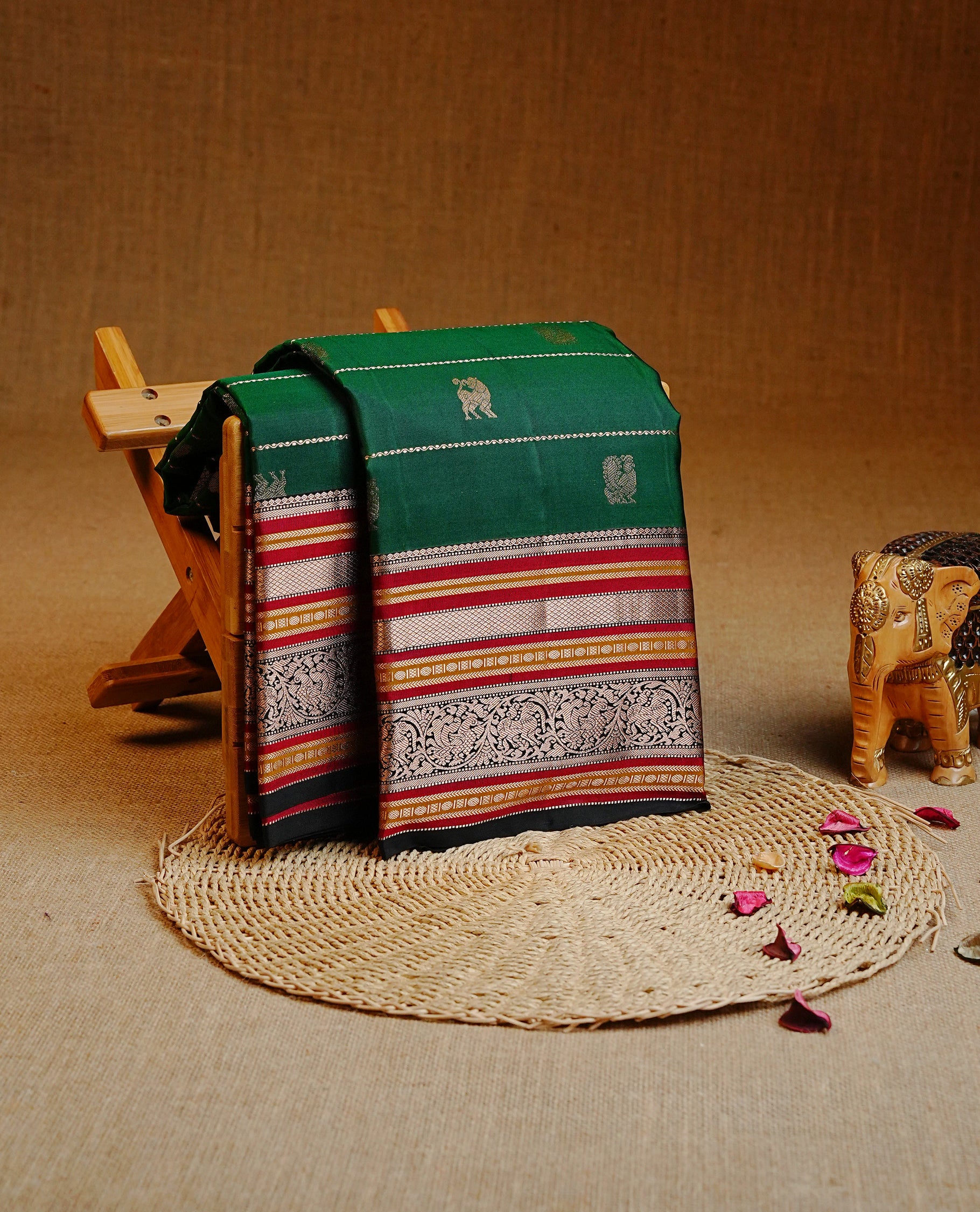 Green colour Kancheepuram silk saree featuring Gold Zari Peacock & stripes on body, enrich Gold Zari with Red, mustard on contrast black border, paired with a Matching blouse piece.