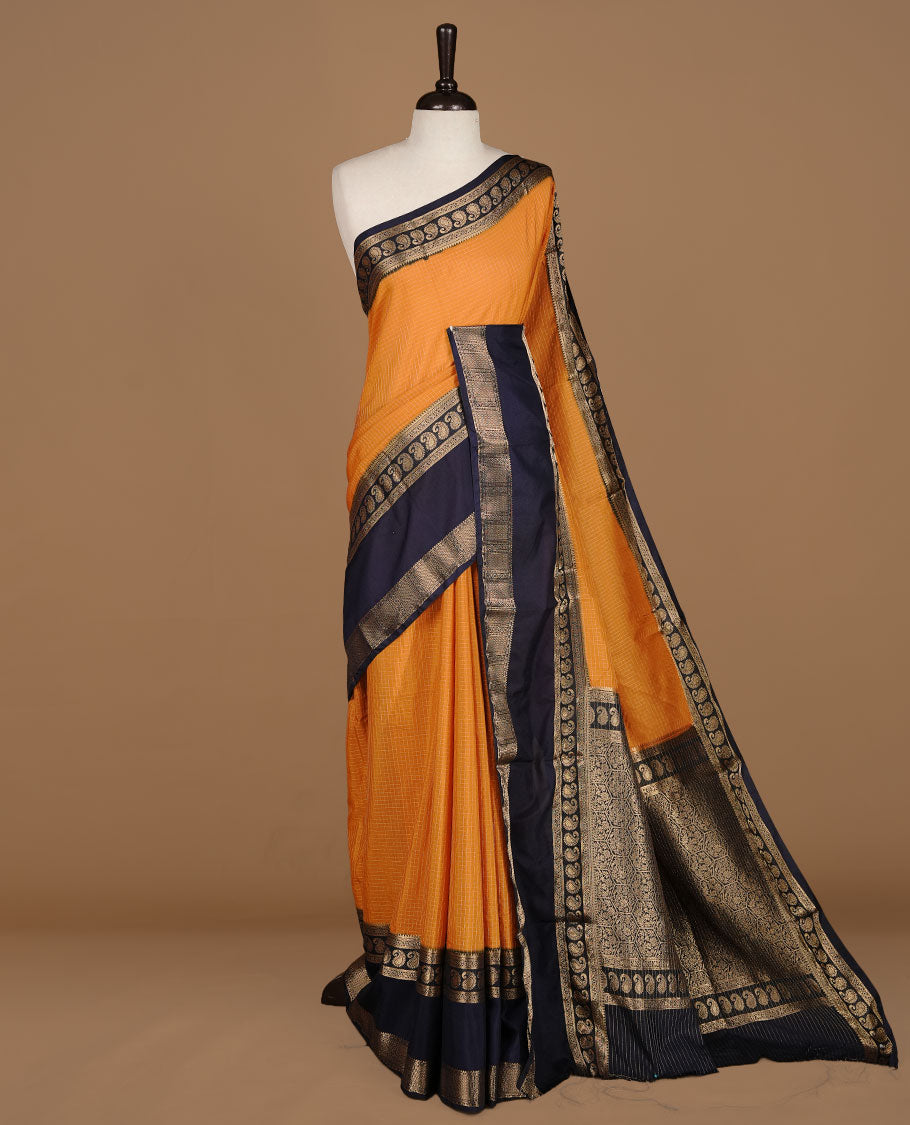 Mustard colour semi georgette saree featuring gold zari check pattern on body, complemented by contrast Blue colour with zari border, paired with matching blouse piece.