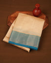 Cream colour tussar silk saree featuring elegant plain body, contrast Blue colour border with gold zari, comes with matching blouse piece.