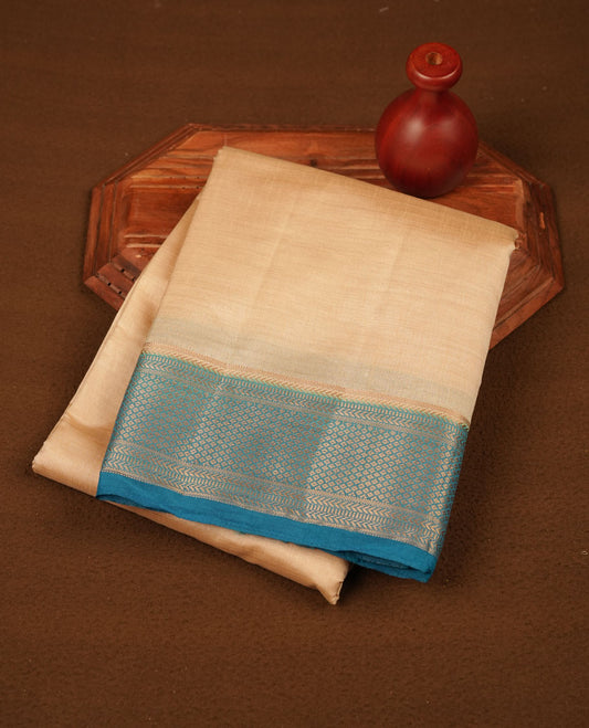 Cream colour tussar silk saree featuring elegant plain body, contrast Blue colour border with gold zari, comes with matching blouse piece.