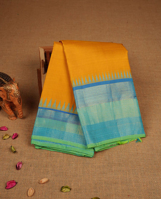 Mustard yellow colour pure traditional Kancheepuram silk saree featuring elegant contrast borders in shades of blue and green with classic zari detailing, beautifully paired with a matching blouse piece