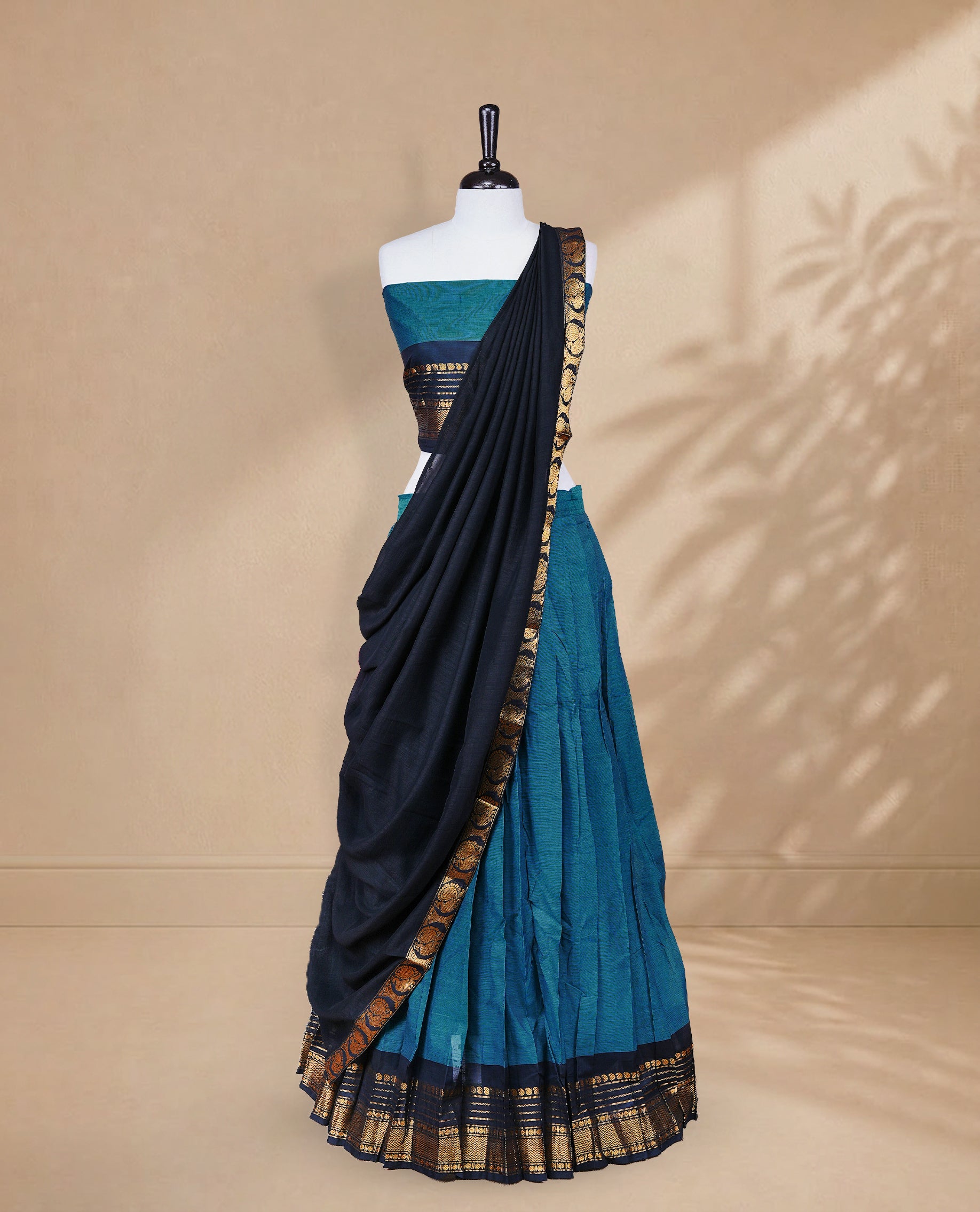 Teal colour Half saree featuring Plain skirt with Zari border on contrast black colour border, Unstitched Blouse and matching dupatta.