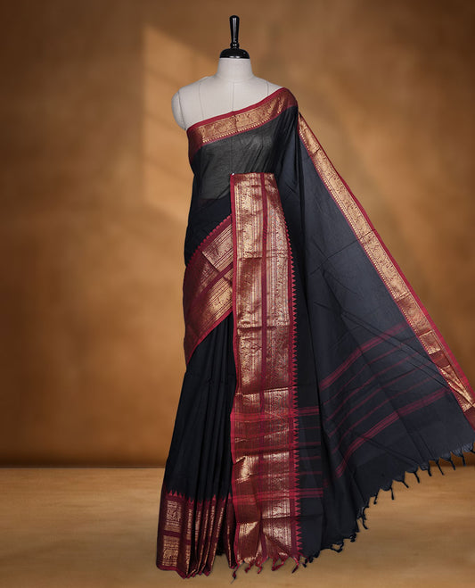 Black colour chettinad cotton saree featuring plain body, contrast maroon colour with traditional gold zari border paired with matching blouse.