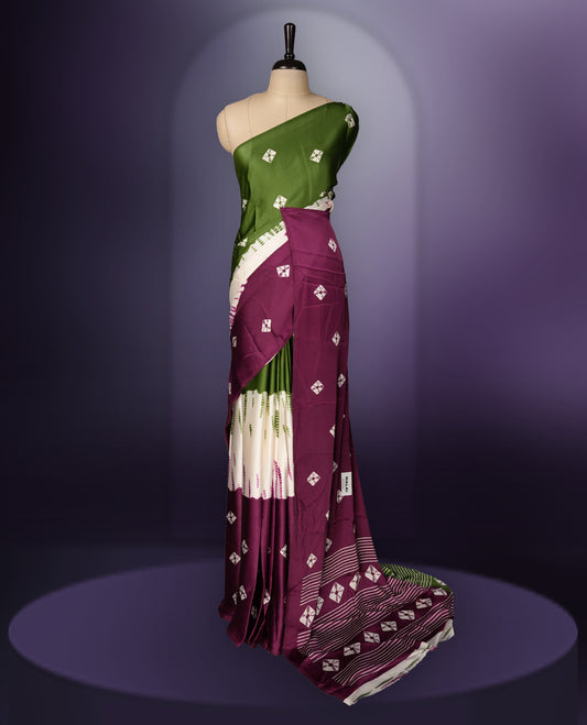 Rich green and purple saree adorned with small woven motifs on the body, enhanced by a contrast border, complemented with a traditional patterned pallu, and paired with a matching blouse.