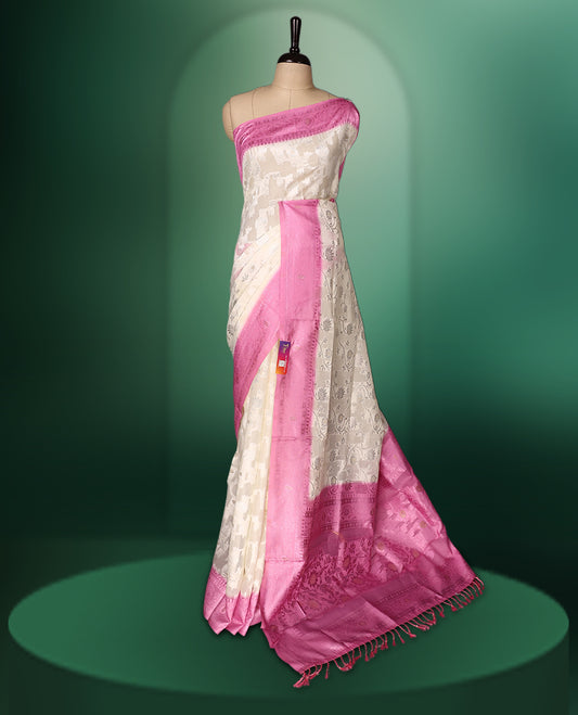White colour saree adorned with delicate self woven motifs across the body, highlighted with a striking Pink woven border and pallu, finished with tassels, and paired with a matching blouse