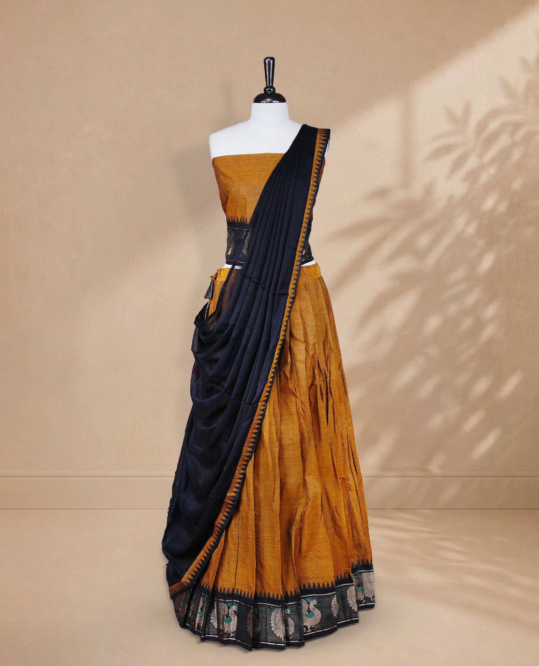 Mustard colour Half saree featuring Plain skirt with Zari border on contrast black colour border, Unstitched Blouse and matching dupatta.