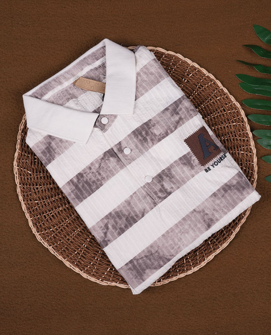Off white and grey colour striped polo T shirt featuring a collared neck with button placket, half sleeves, and a textured fabric design, enhanced with a front chest patch that adds a trendy casual vibe.