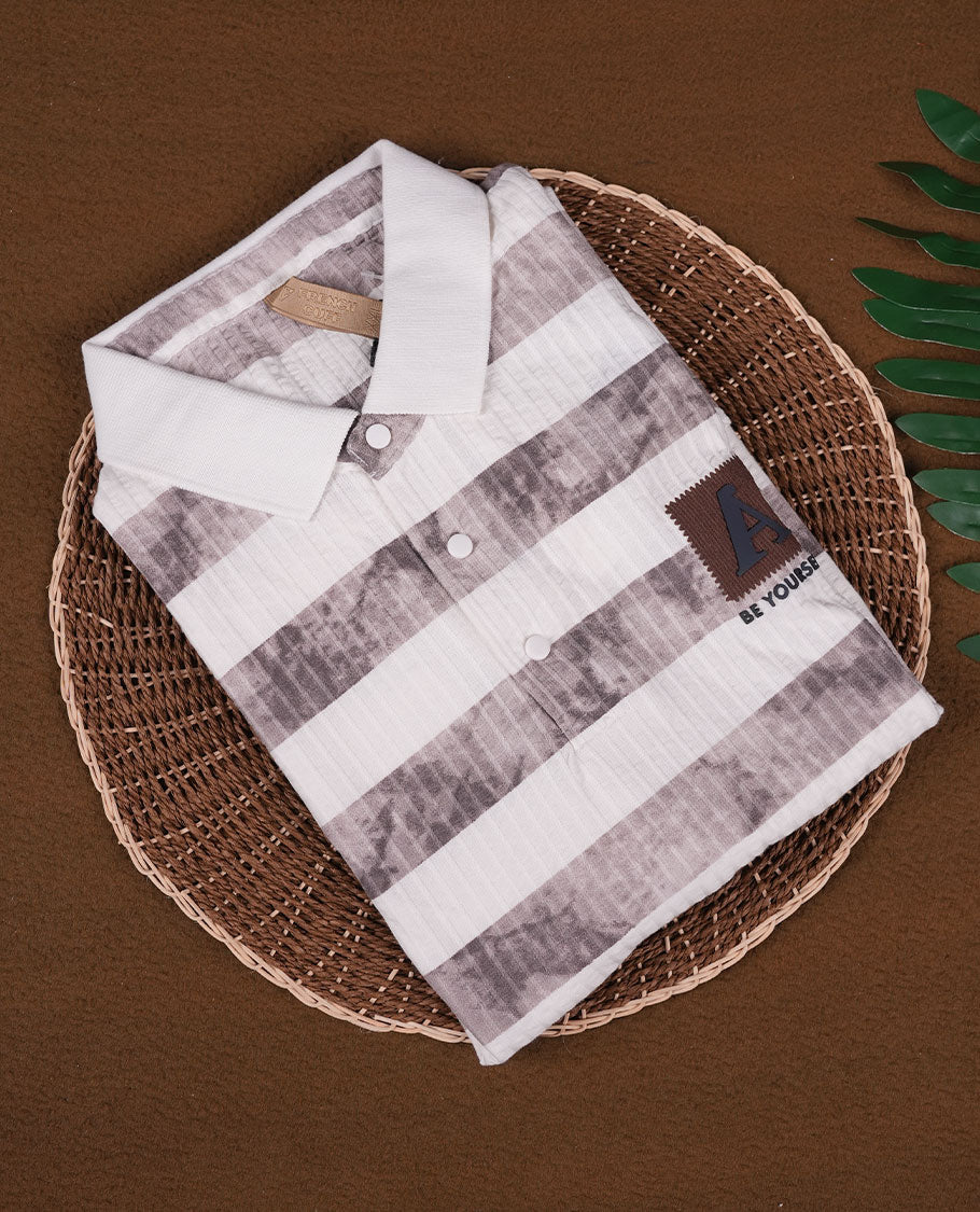 Off white and grey colour striped polo T shirt featuring a collared neck with button placket, half sleeves, and a textured fabric design, enhanced with a front chest patch that adds a trendy casual vibe.