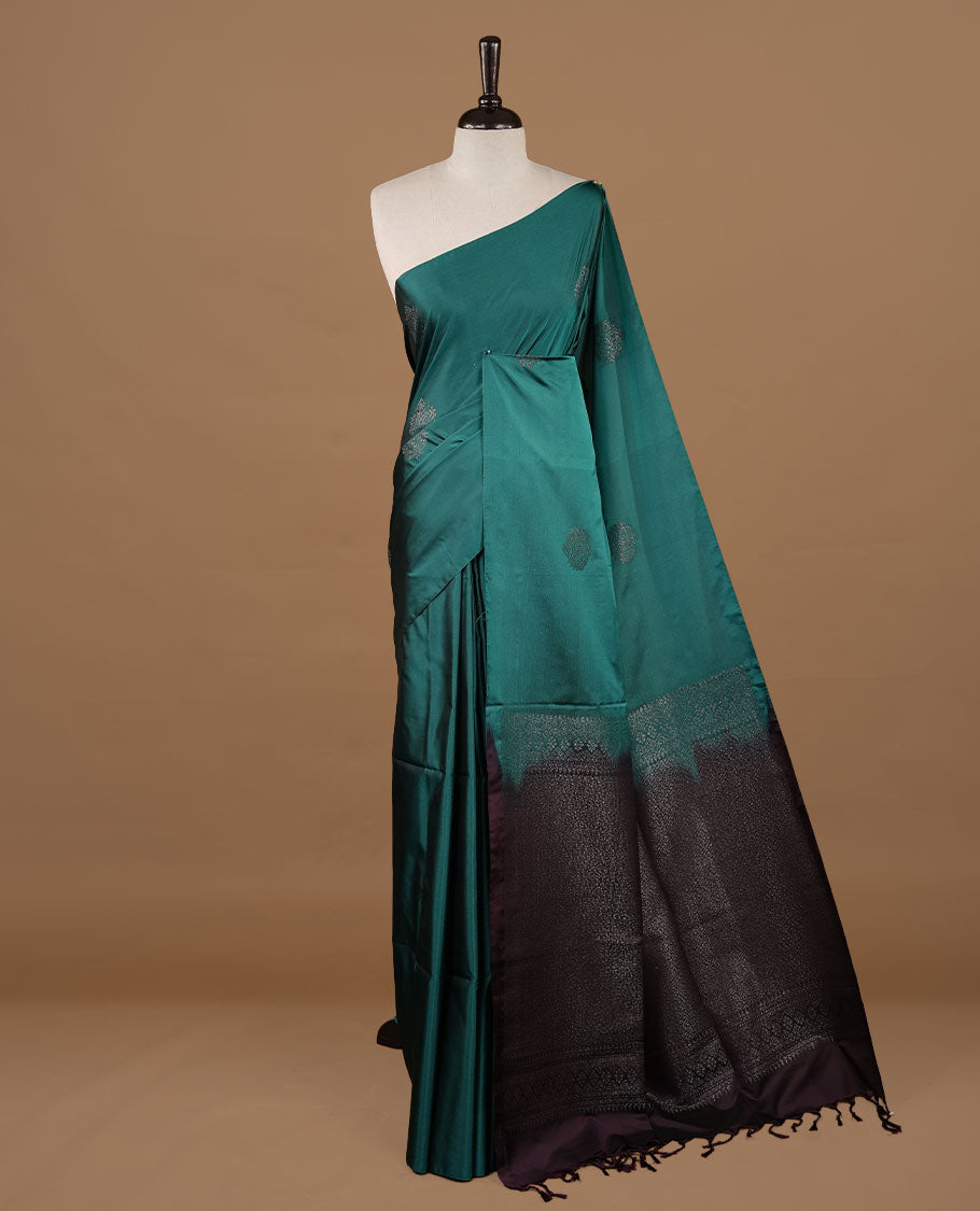 Green colour soft silk saree features a sleek borderless design with intricate antique zari motifs, flowing into a striking contrast Tyrian purple pallu and a matching blouse piece.