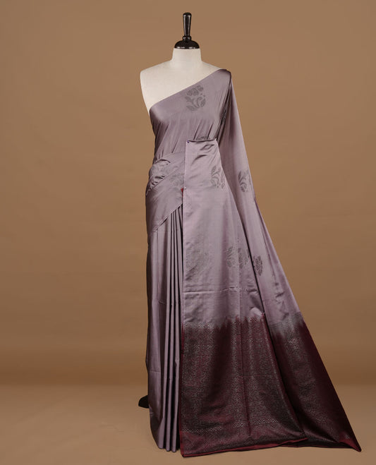 Lavender colour soft silk saree features a sleek borderless design with intricate antique zari motifs, flowing into a striking contrast maroon pallu and a matching blouse piece.