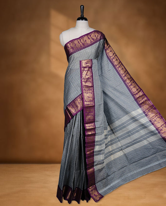 Grey colour sungudi cotton saree featuring gold zari check pattern across body, contrast Purple colour with gold zari peacock pattern on border, without blouse piece.