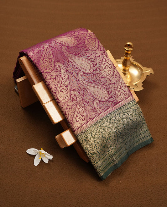 Purple colour semi silk brocade saree featuring intricate Gold Floral kodi & leaf patterns across the body, complemented by a contrast Green colour woven border and pallu, paired with a matching blouse.