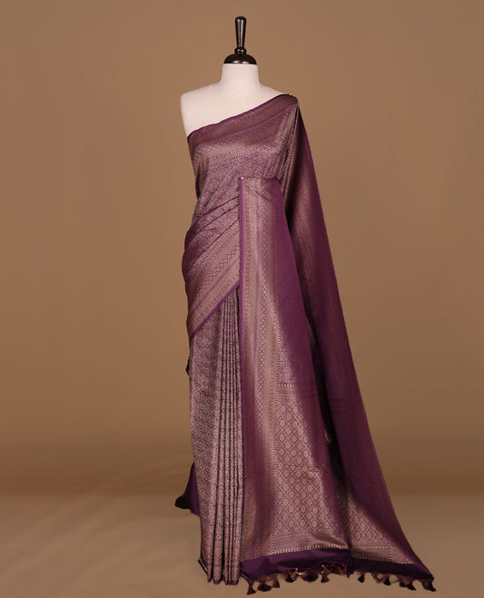 Purple colour semi banaras katan saree featuring Gold zari Pattern across body, complemented by self colour with zari border, paired with matching blouse piece.
