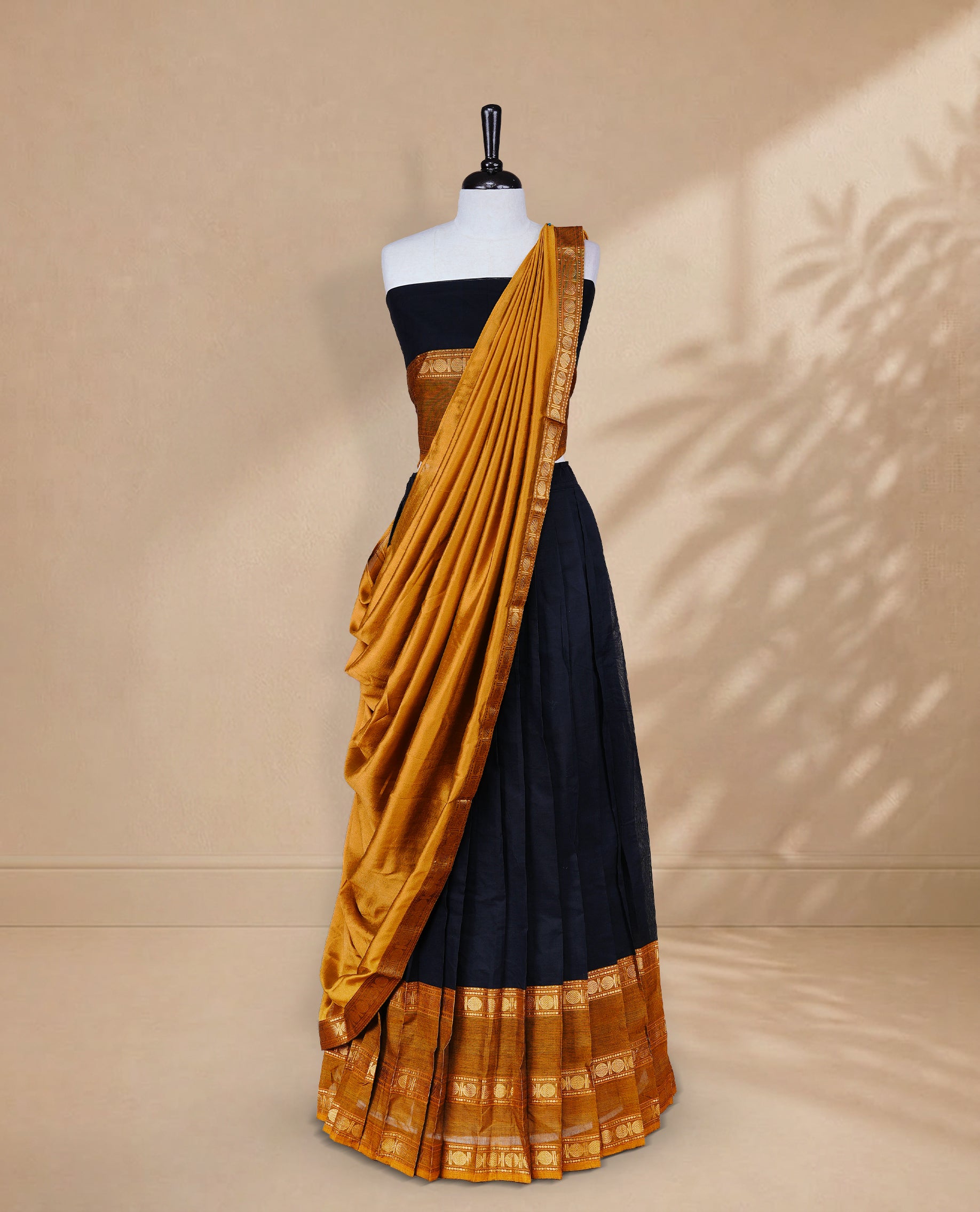 Black colour Half saree featuring Plain skirt with Zari border on contrast Mustard colour border, Unstitched Blouse and matching dupatta.