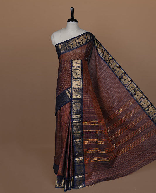 Brown colour sungudi cotton saree featuring gold zari check pattern across body, contrast Dark blue colour with gold zari peacock and floral pattern on border, without blouse piece.