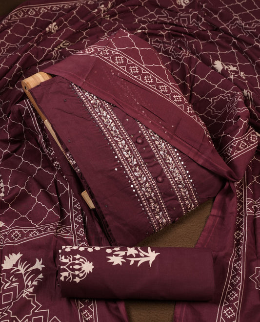 Wine colour churidar material featuring delicate thread embroidery with mirror work on the front panel, paired with a printed dupatta and matching bottom.