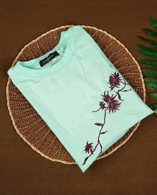 Sky blue colour T shirt featuring intricate wine coloured embroidery on the front and back, designed with a classic round neck and short sleeves & it offers a stylish and comfortable everyday look.