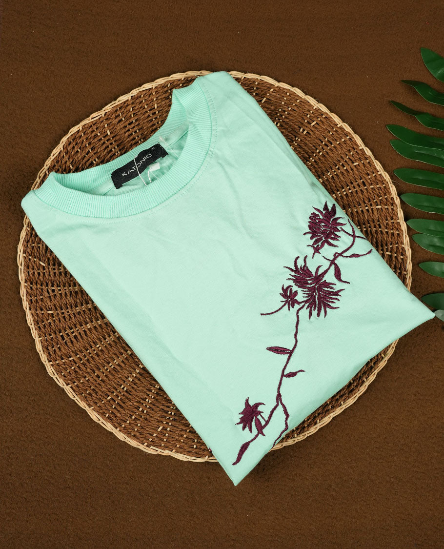 Sky blue colour T shirt featuring intricate wine coloured embroidery on the front and back, designed with a classic round neck and short sleeves & it offers a stylish and comfortable everyday look.