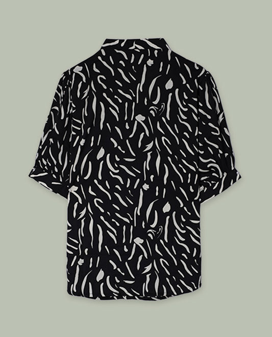 Black short-sleeve shirt top with collared neckline and all-over white abstract dash print, shown from the back.