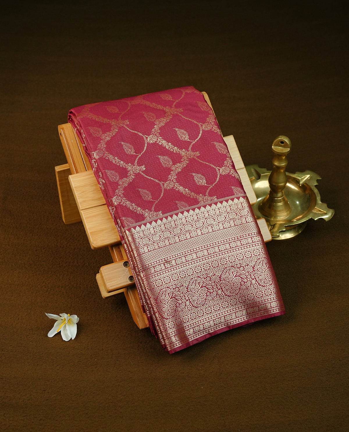 Deep wine colour semi wedding saree featuring light gold zari floral kodi pattern motifs across the body, complemented by contrast self colour traditional border. Comes with a matching blouse piece.