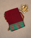Maroon colour Narayanapattu cotton saree with a plain body, complemented by a Green colour with Gold Zari border & contrast pallu, paired with a matching blouse piece.