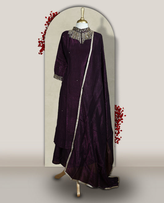 Deep wine colour churidar set with a rich sheen, beautifully adorned with golden cut beads work on the neckline and sleeve borders, Paired with a matching dupatta featuring a subtle zari edge, perfect for a regal festive look.
