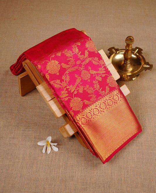 Rani pink colour kancheepuram silk saree featuring gold zari pattern across body, complemented by selfcolour border traditional zari border, paired with matching blouse piece.