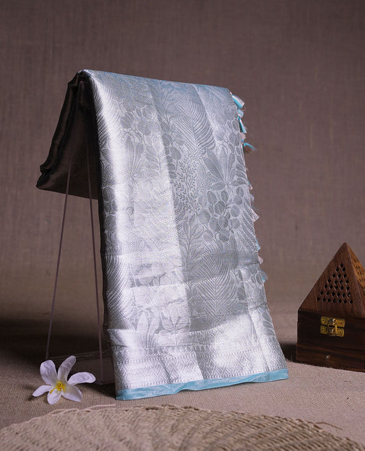 Light blue colour Pure banaras tissue silk saree featuring Silver zari brocade design across body, with silver zari brocade border, finished with a matching blouse.