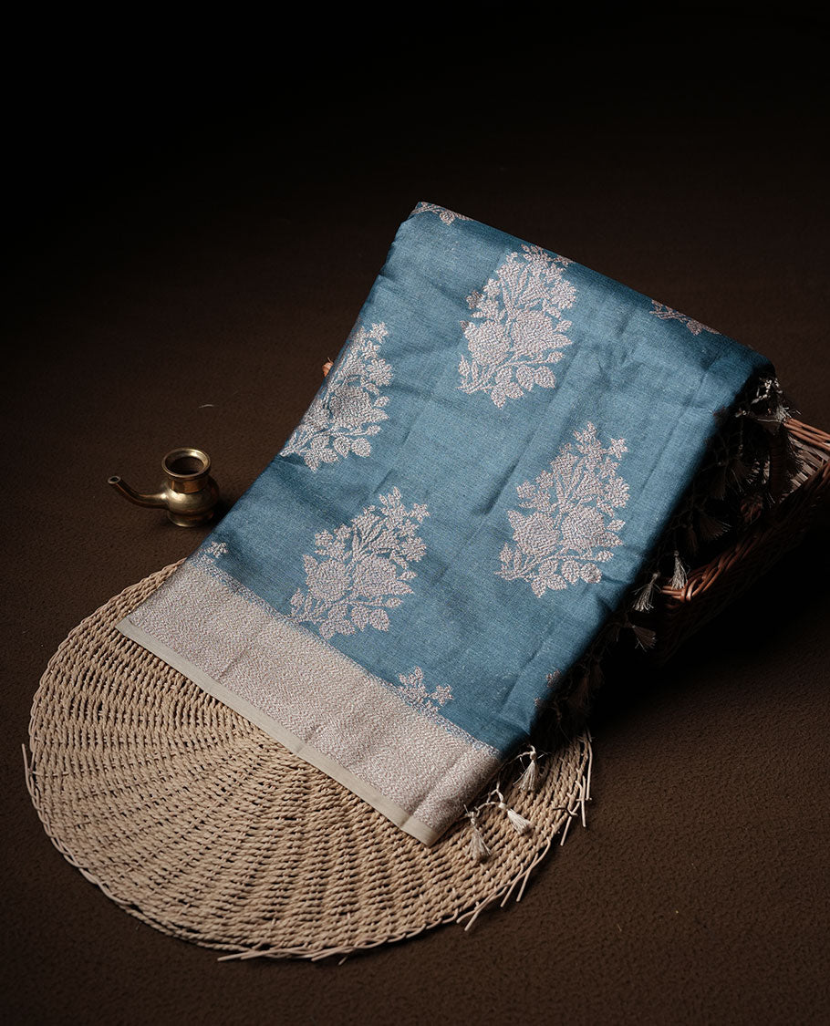 Teal colour pure banaras tusser silk saree highlighting antique zari pattern across body, with contrast cream colour with zari border and paired with matching blouse