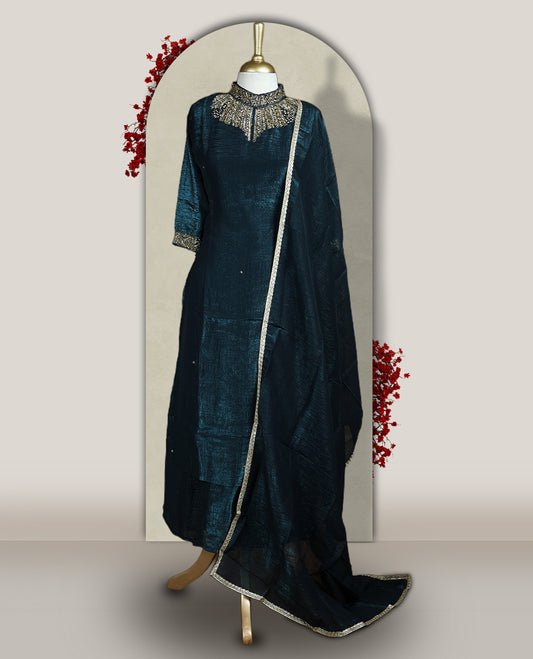 Deep blue colour churidar set with a rich sheen, beautifully adorned with golden cut beads work on the neckline and sleeve borders, Paired with a matching dupatta featuring a subtle zari edge, perfect for a regal festive look.