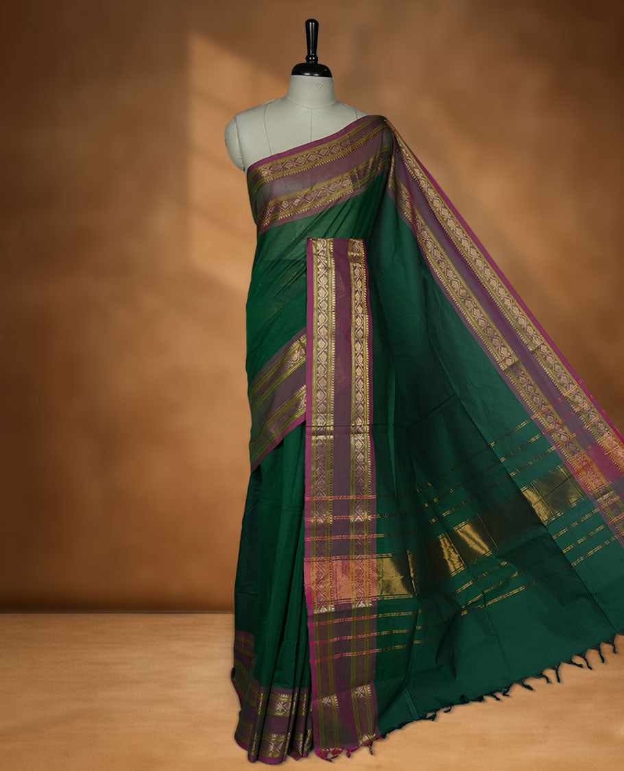 Dark green colour chettinad cotton saree featuring Elegant plain body, contrast Dusty Magenta colour border with gold zari border, pallu and paired with matching blouse.