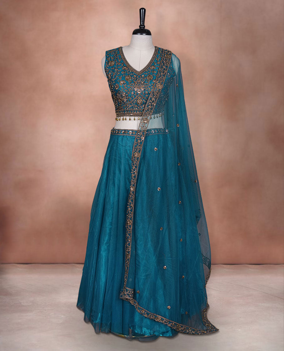 Dark blue colour lehenga set with stitched sleeveless Antique thread embroidered & beats worked  blouse featuring sheer neckline, matching stitched flared lehenga, and plain sheer dupatta.