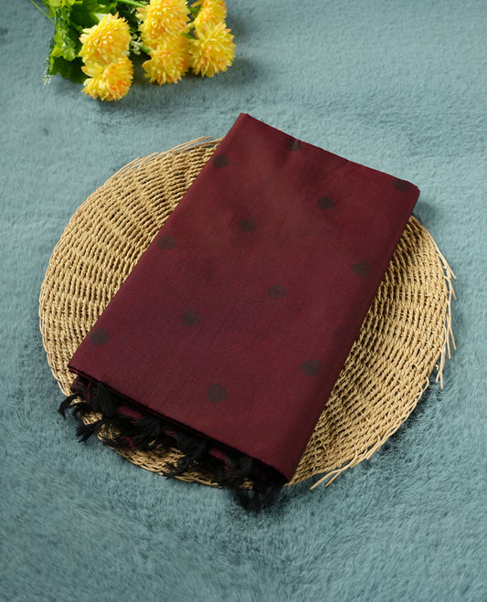 Dark maroon colour poly cotton saree with black abstract butti motifs on the body, paired with a matching pallu with dense black textured round butta pattern, and a coordinated all‑over textured round butta printed blouse piece.