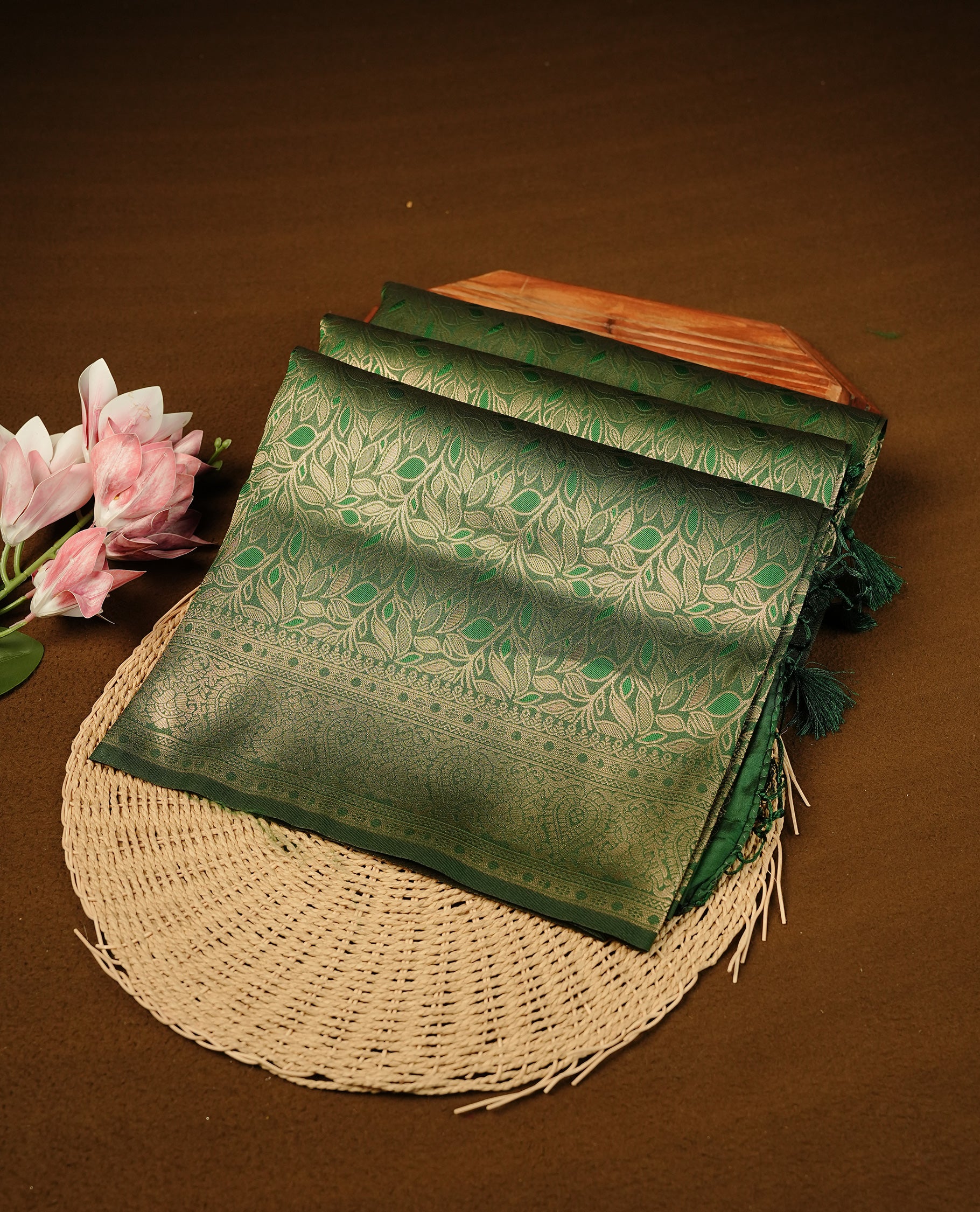Bottle Green  Colour Softie Silk Saree Featuring An All Over Gold Woven Leaf Pattern, Finished With A Matching Border Adorned With Intricate Paisley And Floral Motifs, Paired With A Matching Blouse Piece.
