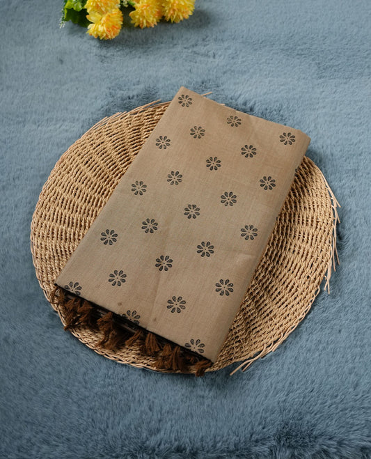 Dark Beige colour poly cotton saree with black floral butti motifs on the body, paired with a matching pallu featuring black ornate floral jaal and stripes on the border, and a coordinated all‑over black paisley printed blouse piece.