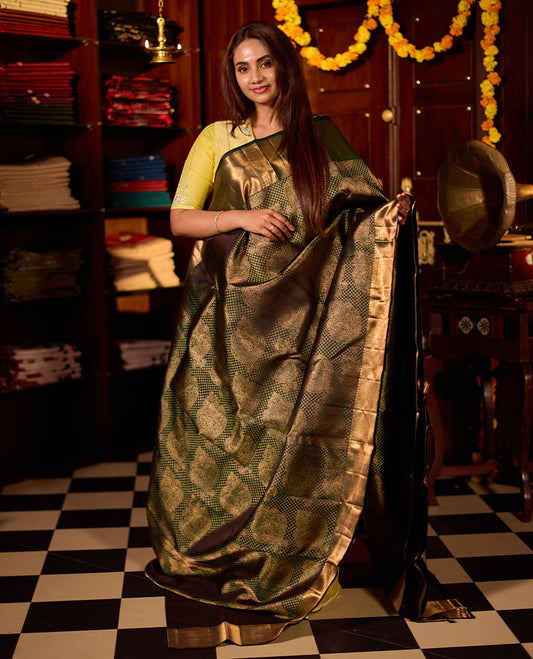 Deep green pure Kancheepuram silk saree featuring elegant gold zari Motifs, a rich gold zari pallu, and a broad gold zari border, paired with a matching blouse.