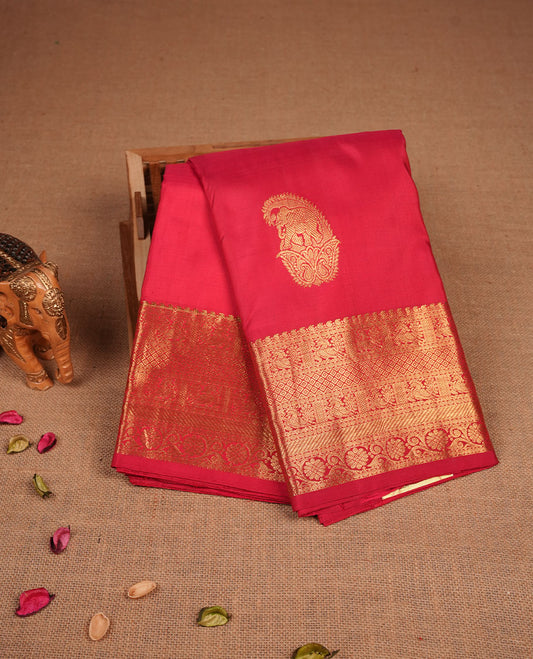 Vibrant red colour pure traditional Kancheepuram silk saree adorned with an elegant zari elephant motif on the body, complemented by a rich gold zari woven border featuring intricate traditional designs, paired with a matching blouse piece.