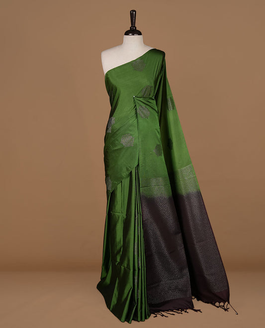 Green colour  soft silk saree features a sleek borderless design with intricate antique zari motifs, flowing into a striking contrast chocolate brown pallu and a matching blouse piece.