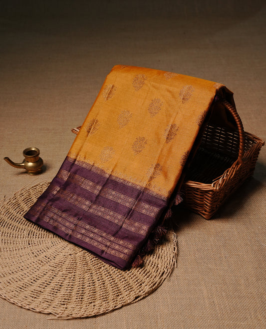 Mustard colour pure tussar banaras silk saree featuring gold zari motifs on body, highlighting contrast Purple colour with zari border, paired with matching blouse piece.