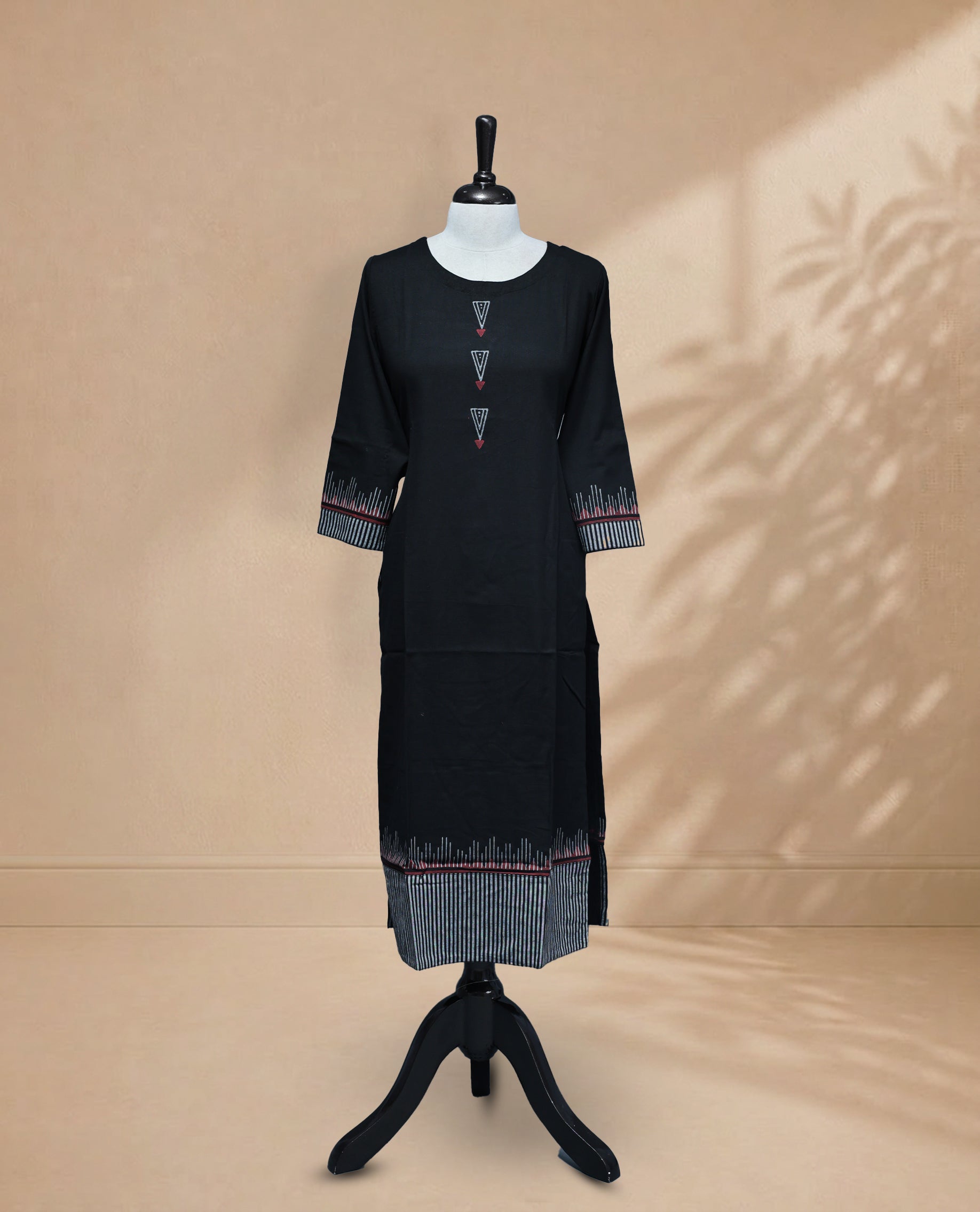Black Kurti featuring vertical grey stripes on the bottom, a round neckline adorned with red and grey triangular detailing, and 3/4 sleeves with a matching design.