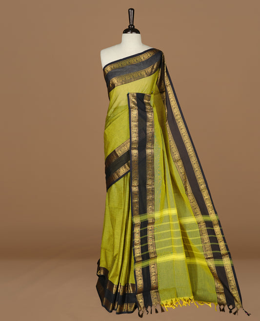 Olive Colour chettinad cotton saree featuring Elegant plain body, complemented by contrast Dark blue colour with gold zari border, paired with matching blouse.