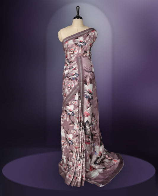 Mauve colour saree adorned with elegant floral prints on the body, enhanced with a subtle matching border, complemented by a beautifully printed pallu featuring blooming flowers, and paired with a matching blouse.