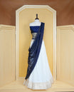 Cream colour Semi Stitched Dhavani Set Cream colour Skirt With Floral Motifs on Border, Paired with Contrast Navy Blue colour With Gold zari motifs on Unstitched Blouse, Elegant Dupatta For Prefect look.