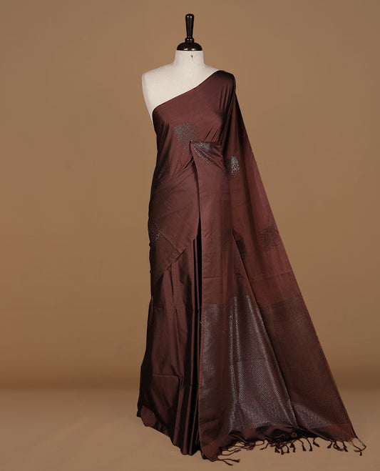 Chocolate soft silk saree features a sleek borderless design with intricate antique zari motifs, flowing into a seamless self colored pallu and a matching blouse piece.