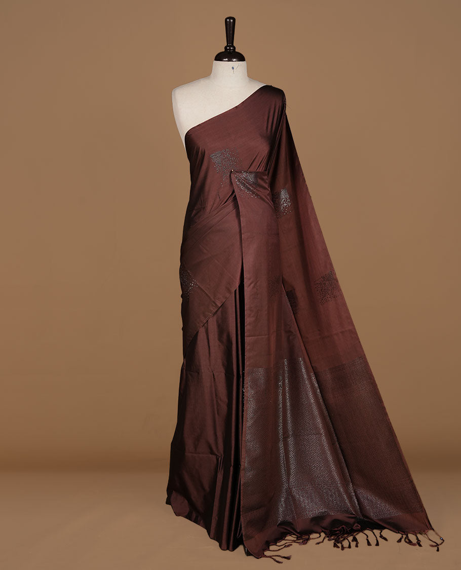 Chocolate soft silk saree features a sleek borderless design with intricate antique zari motifs, flowing into a seamless self colored pallu and a matching blouse piece.
