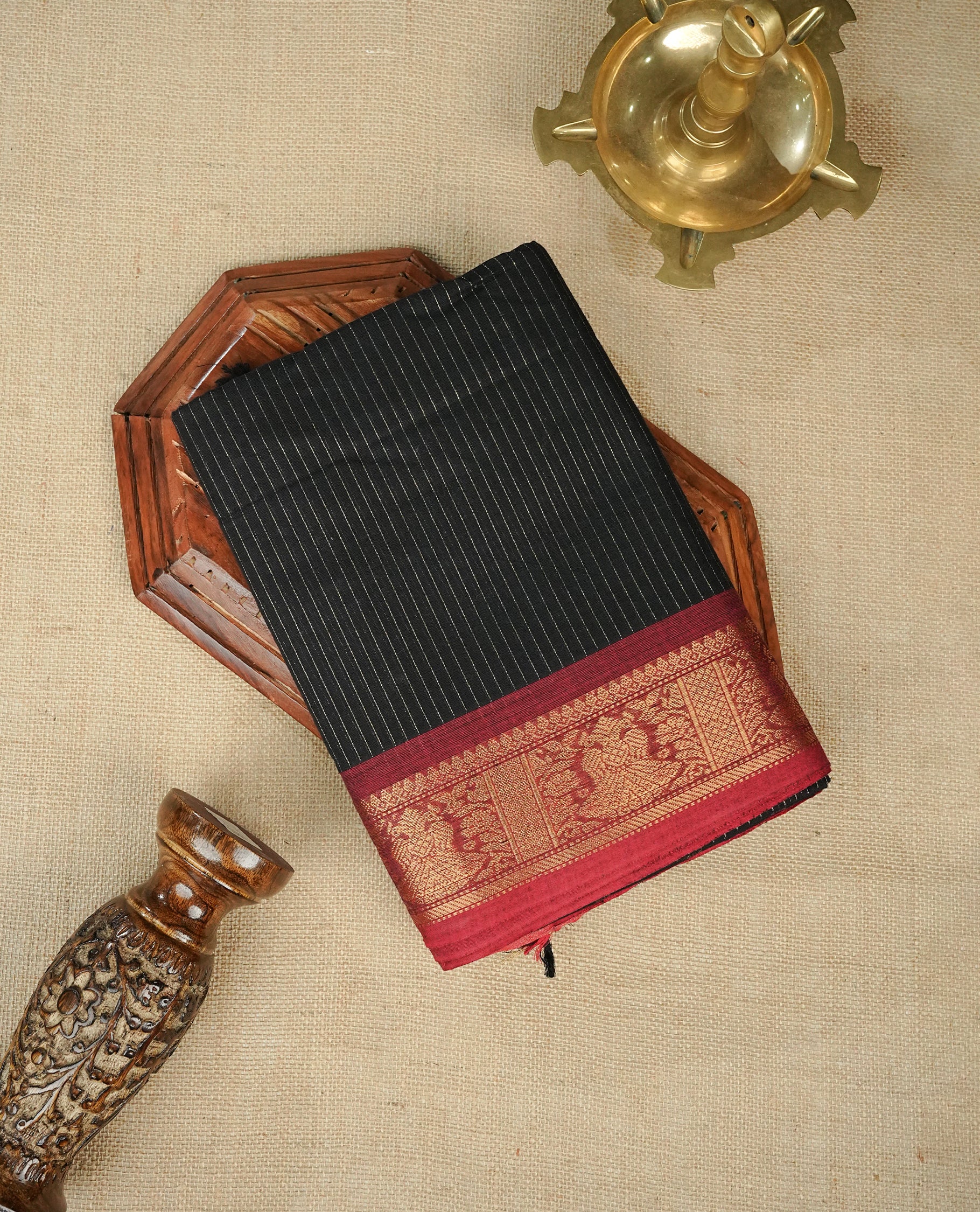 Black colour chettinad cotton saree Featuring Gold zari Strips on body, complemented by contrast Maroon colour with zari border, comes with matching blouse piece.