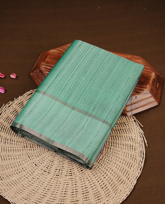 Aqua colour semi tussar silk saree featuring elegant gold zari dotted stripes across the body, enhanced with a rich zari woven border. Comes with a matching blouse piece.