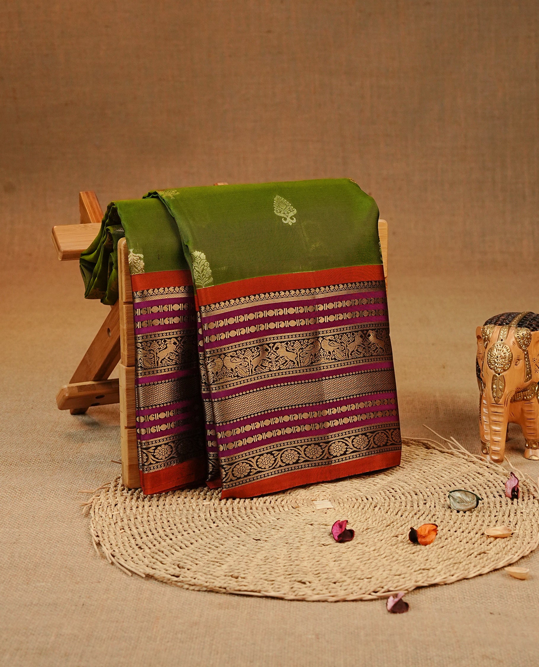 Olive colour Kancheepuram silk saree featuring Gold zari Motifs on body, complemented by Multicolour with Traditional border, comes with matching blouse piece.